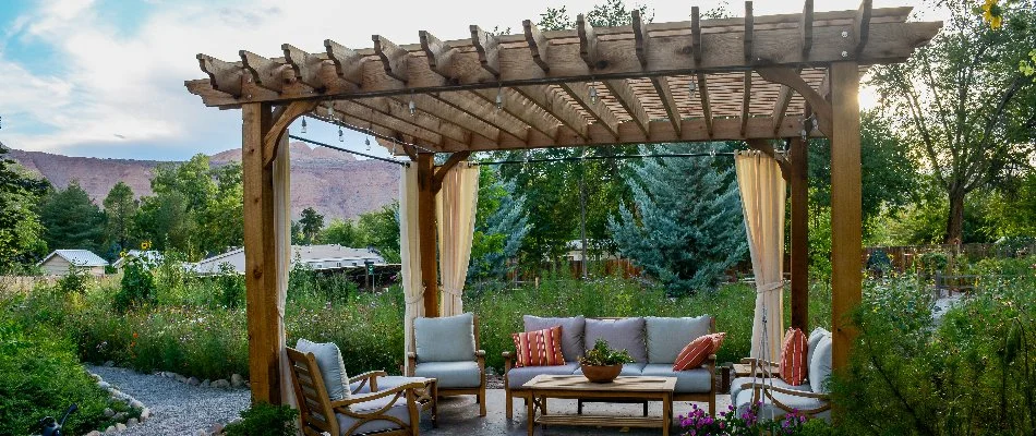 Wooden pergola with furniture under it on a property in Matthews, NC.