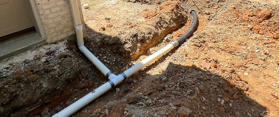 A French drain connected to a downspout, creating a "T" shape in Matthews, NC.