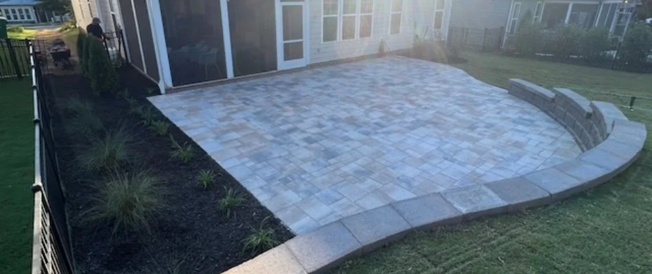 Patio and retaining wall in New Salem, NC, beside a mulched landscape bed.