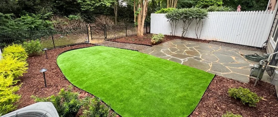 Patio in Red Cross, NC, with artificial turf and landscape beds.