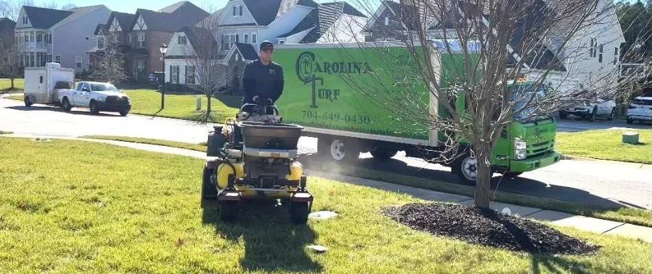 Lawn care employee treating residential lawn in Mount Holly, NC.